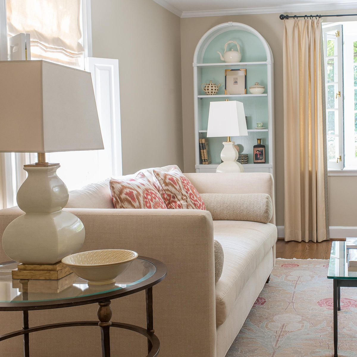 Living room with beige sofa, glass coffee table, and decorative elements.